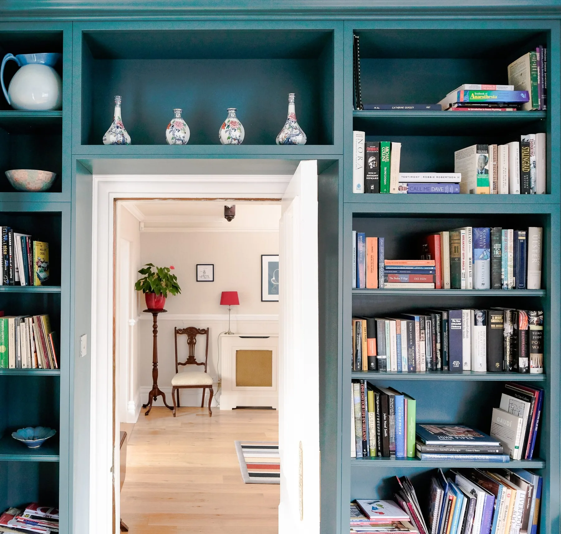 A view through an arched doorway into a fitted library