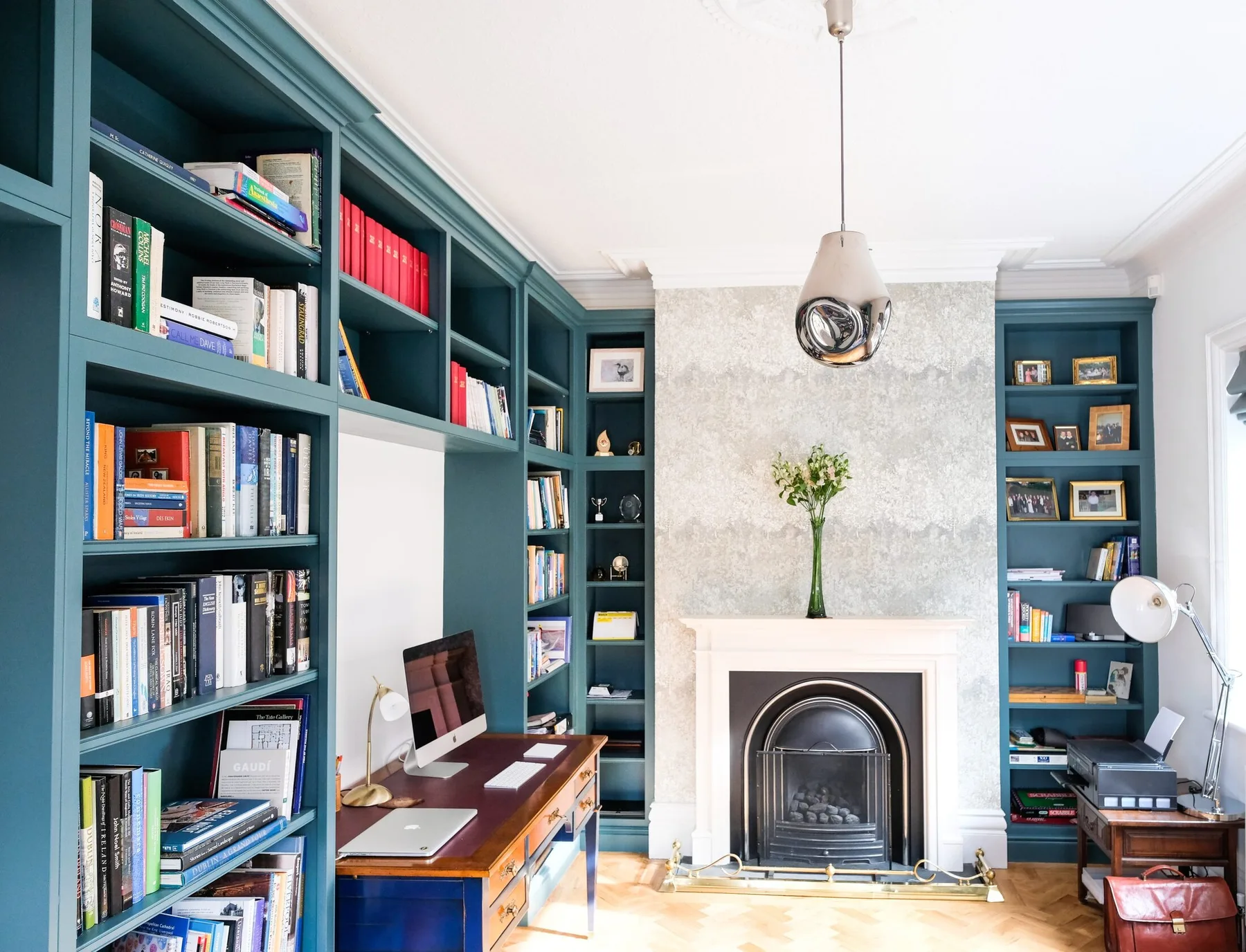 A deep green fitted library designed by Corinthian